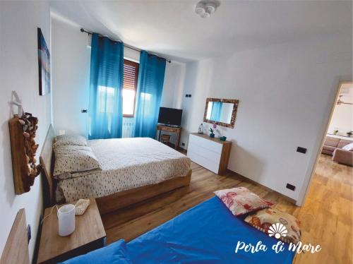 皮昂比诺Appartamento Perla di Mare的一间卧室配有两张床、一张桌子和一面镜子