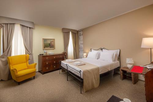 罗维尼海瑞缇吉安吉洛多拉酒店的一间卧室配有一张床和一张黄色椅子