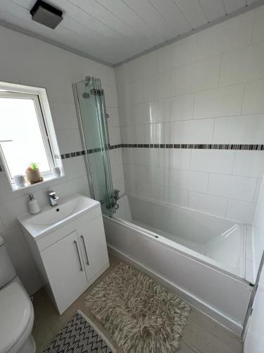 卢顿Single room with Smart Tv的带浴缸、卫生间和盥洗盆的浴室
