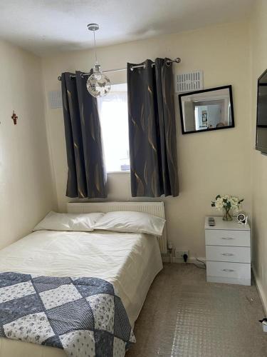 卢顿Single room with Smart Tv的一间卧室配有床和带窗帘的窗户