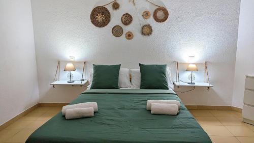 洛斯克里斯蒂亚诺斯La Palmera - Apartamento a 600mt de la playa - Los Cristianos的一间卧室配有带两个枕头的绿色床