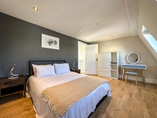 伦敦Parkway residences的一间卧室配有一张床铺、一张桌子和一台冰箱
