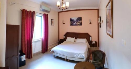 奥兰Hotel Les Ambassadeurs的一间卧室设有一张床和一个窗口