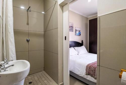 巴利托巴利托背包客旅舍的一间带水槽、一张床和淋浴的浴室