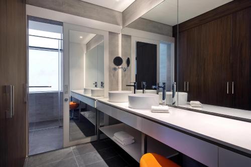 迪拜Aloft Dubai Airport的一间带两个盥洗盆和大镜子的浴室