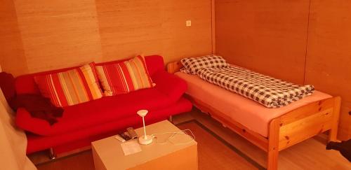 KlosterlechfeldSouterrain Zimmer mit Sauna的小房间设有红色的沙发和桌子