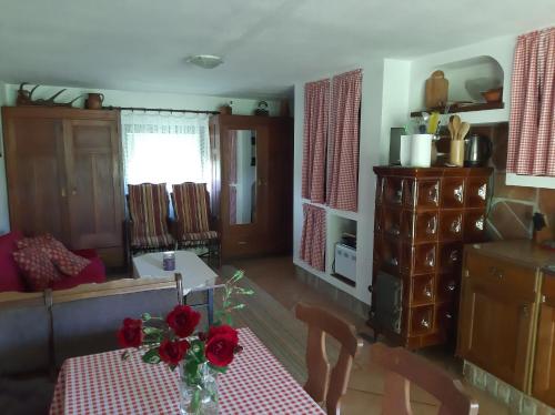 KrapjeHoliday Home Bojko的客厅里设有一张带红色鲜花的桌子
