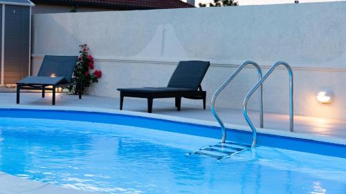 扎顿Booking Zaton Villa Martinova holiday house with swimming pool的一个带两把椅子和一把椅子的游泳池