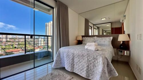 戈亚尼亚Apartamento ao lado Flamboyant Shopping em Goiânia的一间卧室设有一张床和一个大窗户
