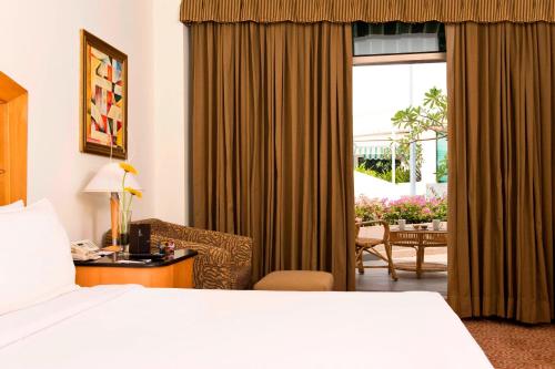 钦奈世茂皇家艾美钦奈酒店的酒店的客房 - 带一张床、椅子和窗户