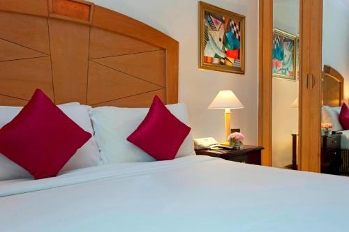 钦奈世茂皇家艾美钦奈酒店的卧室配有带红色枕头的大型白色床