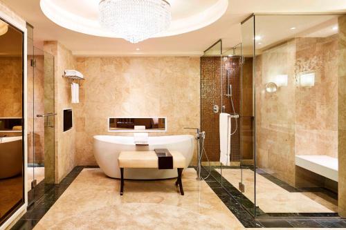 万隆万隆喜来登酒店的带浴缸和玻璃淋浴间的浴室。