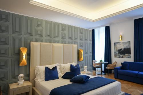 罗马Màs Boutique Hotel Rome的一间卧室配有一张床和一张蓝色的沙发