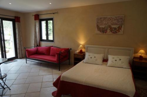 萨尔泰纳Chambre d'Hôtes Domaine Pero Longo的一间卧室配有一张床和一张红色的沙发