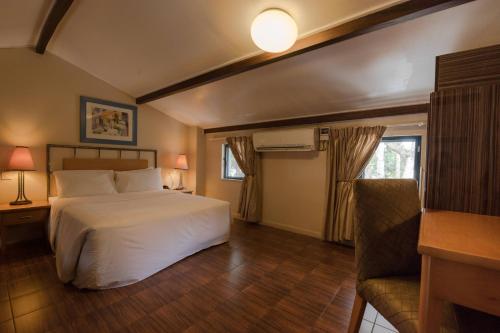 达累斯萨拉姆牡蛎湾普罗蒂酒店的卧室配有白色的床和沙发