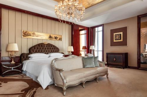 镇江镇江康华汇利喜来登酒店的一间卧室配有一张床、一把椅子和一个吊灯。