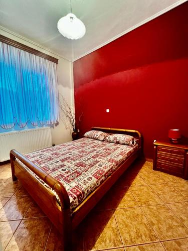 KaryesKolovos House的一间卧室配有一张红色墙壁的床