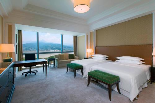福州福州中庚喜来登酒店的酒店客房配有两张床和一张书桌