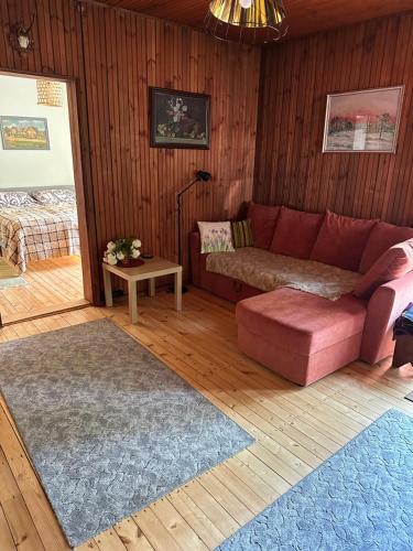 PalaVallaku Guesthouse的客厅配有红色的沙发和桌子