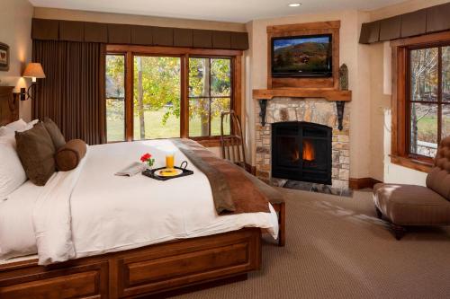帕克城傲途格精选酒店帕克城的一间卧室设有一张大床和一个壁炉