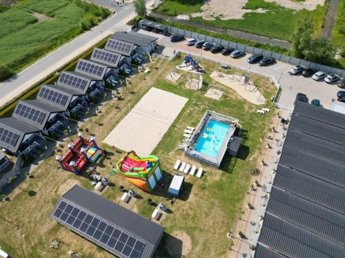 鲁斯诺沃Holiday-Camp的享有带太阳能电池板和游泳池的建筑的顶部景致