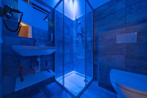 魏勒格Haus Weyregg - Pension的一间带玻璃淋浴和水槽的浴室