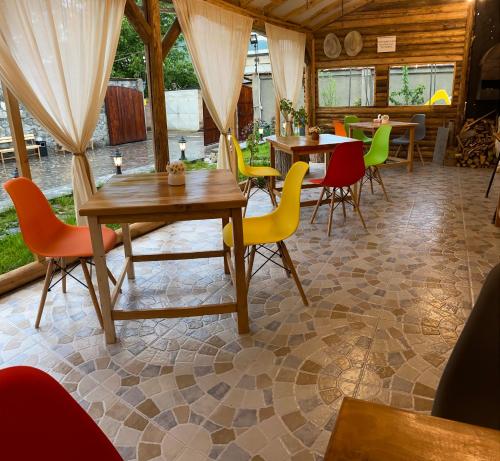 瓦纳佐尔NOY Guest House B&B的用餐室配有桌子和五颜六色的椅子