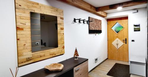潘基阿Bilocale Nel Cuore Della Val Di Fiemme的一间配有电视和木墙的客房