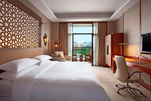 清远清远狮子湖喜来登度假酒店的酒店客房设有一张大床和一张书桌。
