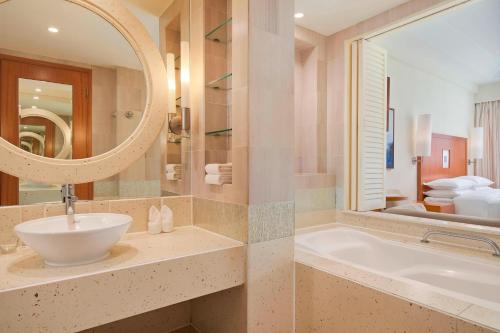 三亚三亚亚龙湾喜来登度假酒店(免税店9.5折和巴士+旅拍)的一间带水槽、浴缸和镜子的浴室