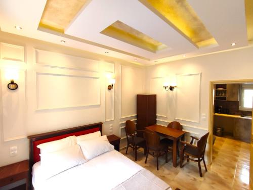 沃洛斯Villa Miltiadis GreeceFyloxenia的一间卧室配有一张床和一张桌子及椅子