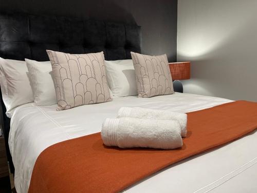 米德兰Exec Oasis @Ellipse的一张白色的大床,配有棕色的毯子和枕头