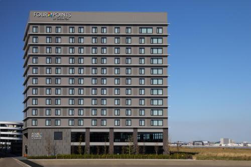 常滑市Four Points by Sheraton Nagoya, Chubu International Airport的一座高大的灰色建筑,有许多窗户