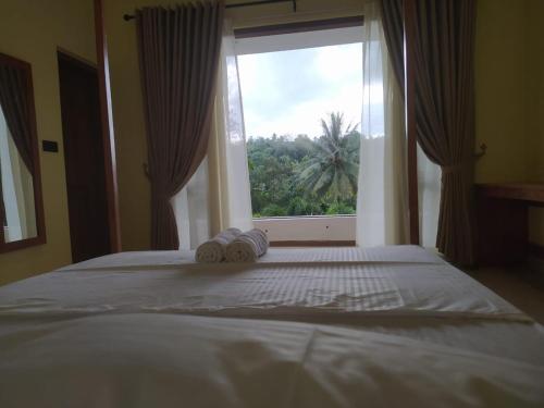 康提Kandy Lotus House的一间卧室设有一张大床和大窗户