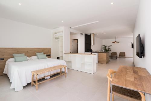 伊维萨镇Bossa Bay Suites with Private Pool - MC Apartments Ibiza的一间白色卧室,配有床和厨房