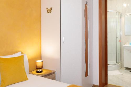马林斯卡Vila Panorama的一间卧室配有一张黄色枕头的床和一间浴室