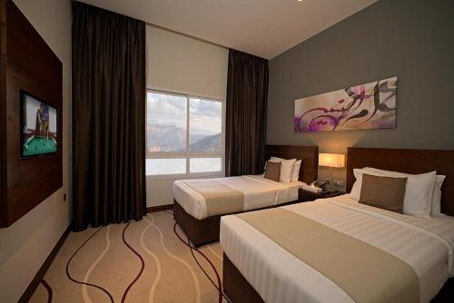 拉斯阿尔卡麦Action Hotel Ras Al Khaimah的酒店客房设有两张床和窗户。