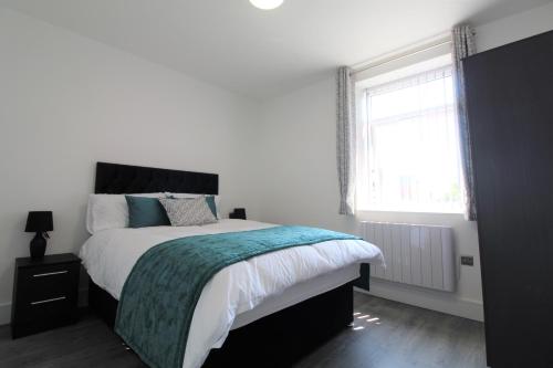 普雷斯顿F6 Hammonds Row的白色的卧室设有一张大床和一个窗户