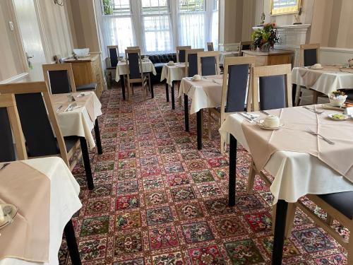 滨海克拉克顿石岩酒店的餐厅配有桌椅和白色的桌布