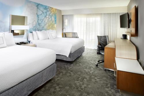 州学院斯泰特科利奇万怡酒店的酒店客房设有两张床和电视。
