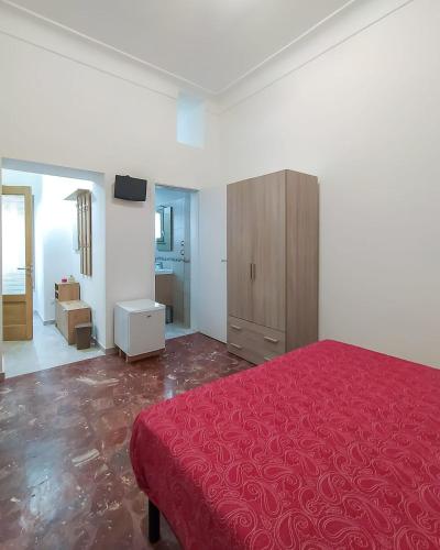 圣维托诺曼Nopal casa vacanze的一间卧室配有红色的床和木制橱柜