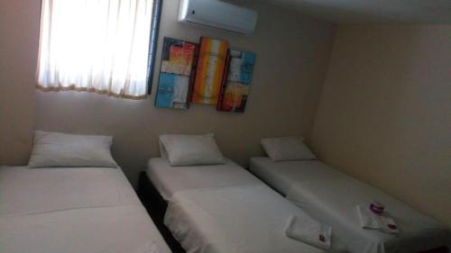 MaicaoEL Dorado Hotel Maicao的小型客房 - 带2张床和窗户
