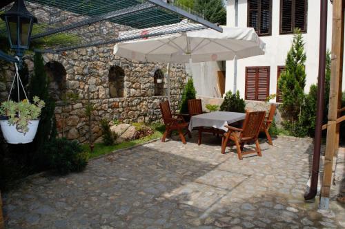 奥赫里德Villa Scandik Ohrid的露台的遮阳伞下的桌椅