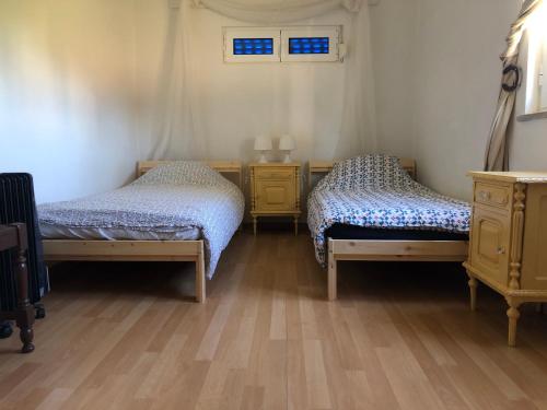 MoitaHERDADE PALMA t2的铺有木地板的客房内的两张床