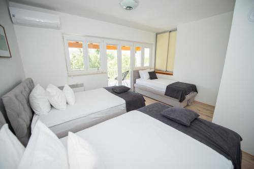 布拉加伊Villa Kosor Spring的一间带两张床和一张沙发的卧室