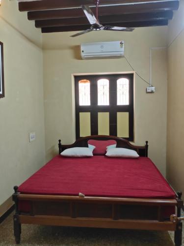 蓬蒂切里Elite Heritage Stay的一间卧室配有一张带红色毯子的大床