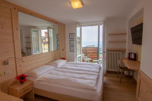 波斯科米拉拉戈酒店的卧室设有白色的床和大窗户