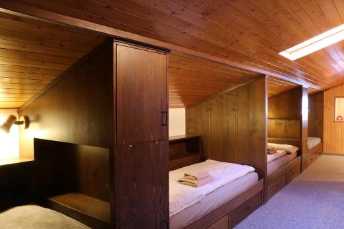 贝尔金Chesa Dominium的木制客房内的一间卧室配有两张床