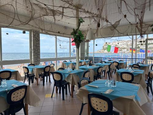 佩斯基奇Villa Ialillo的一间设有蓝色桌椅的海洋餐厅