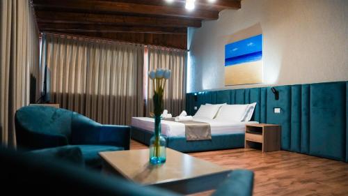 都拉斯Hotel Majestic的酒店客房配有床、沙发和桌子。